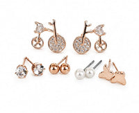 “SOVAR five-pair stud earrings set featuring bicycle designs, clear round stones, gold-tone balls, white pearl-style studs and butterfly shapes