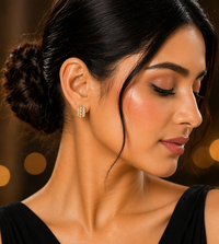 Woman wearing a wide gold-tone crystal hoop earring with a black outfit and her hair in a low bun.