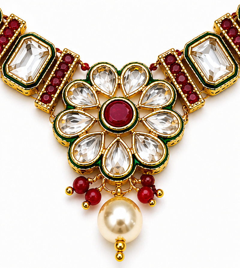 Close-up of a red-centred floral pendant with clear teardrop petals, green enamel outlines, red beads and a white pearl-style drop.